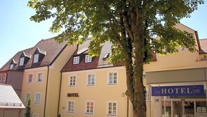 A hotel with a yellow facade, multiple windows, and a sign indicating it is a hotel. - Klassik Hotel Am Tor (Weiden in der Oberpfalz)