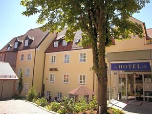 A hotel with a yellow facade, multiple windows, and a sign indicating it is a hotel. - Klassik Hotel Am Tor (Weiden in der Oberpfalz)