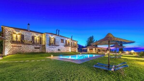 A stone building with a swimming pool and outdoor seating. - Agrikia One Bedroom Apartment (Zakynthos)