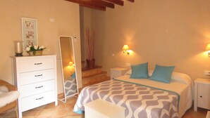 Un dormitorio con una cama, mesitas de noche, un aparador, un espejo y una escalera.