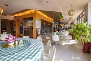 A hotel dining area with round tables, chairs, and potted plants. - Jinjiang Inn (Baoding Junxiao Square) (Baoding)
