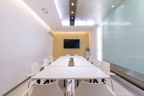 A conference room with a long table, chairs, a flat-screen TV, and a glass partition. - Jinjiang Inn (Baoding Junxiao Square) (Baoding)