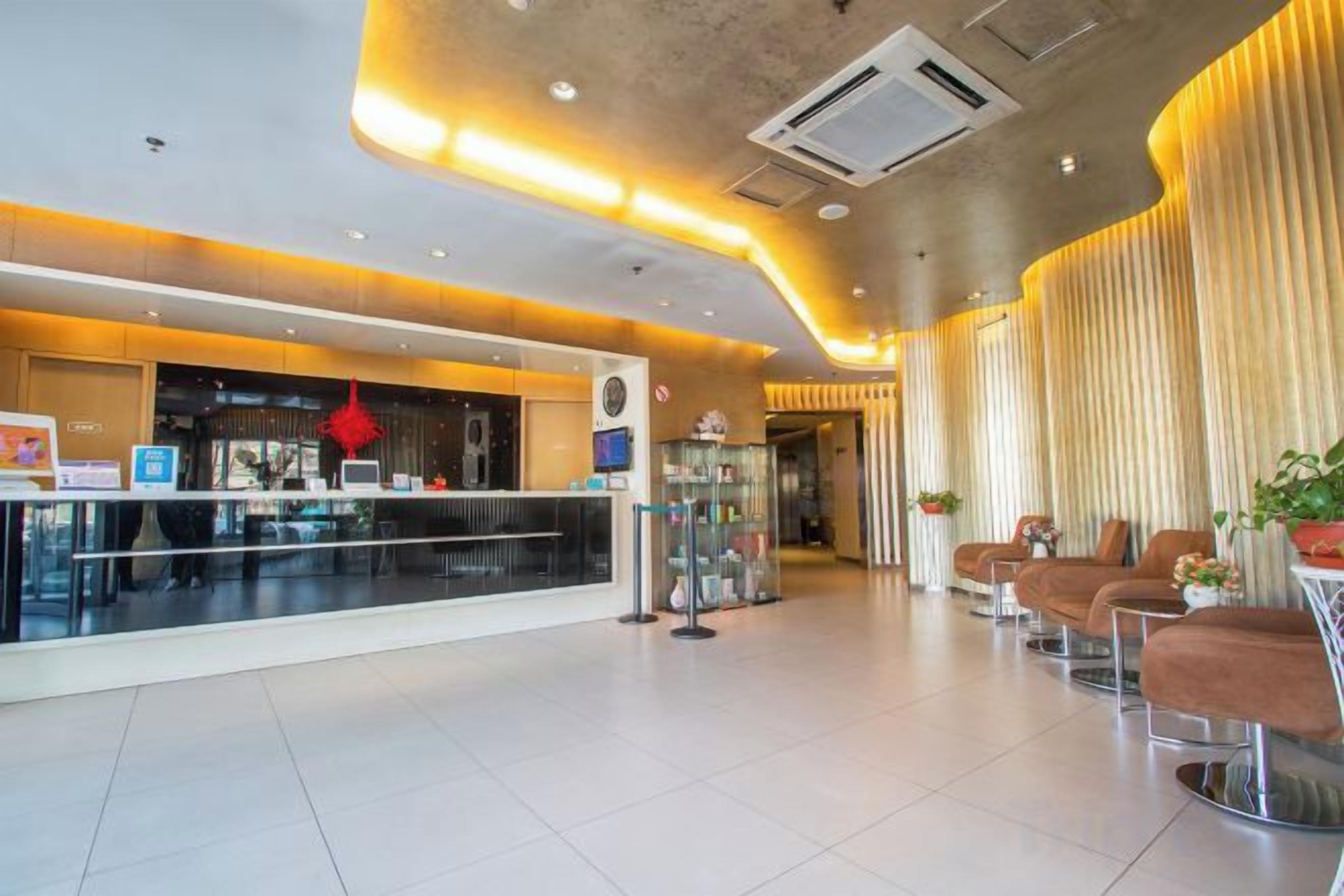 Un vestíbulo de hotel con recepción, zona de estar y diseño moderno.