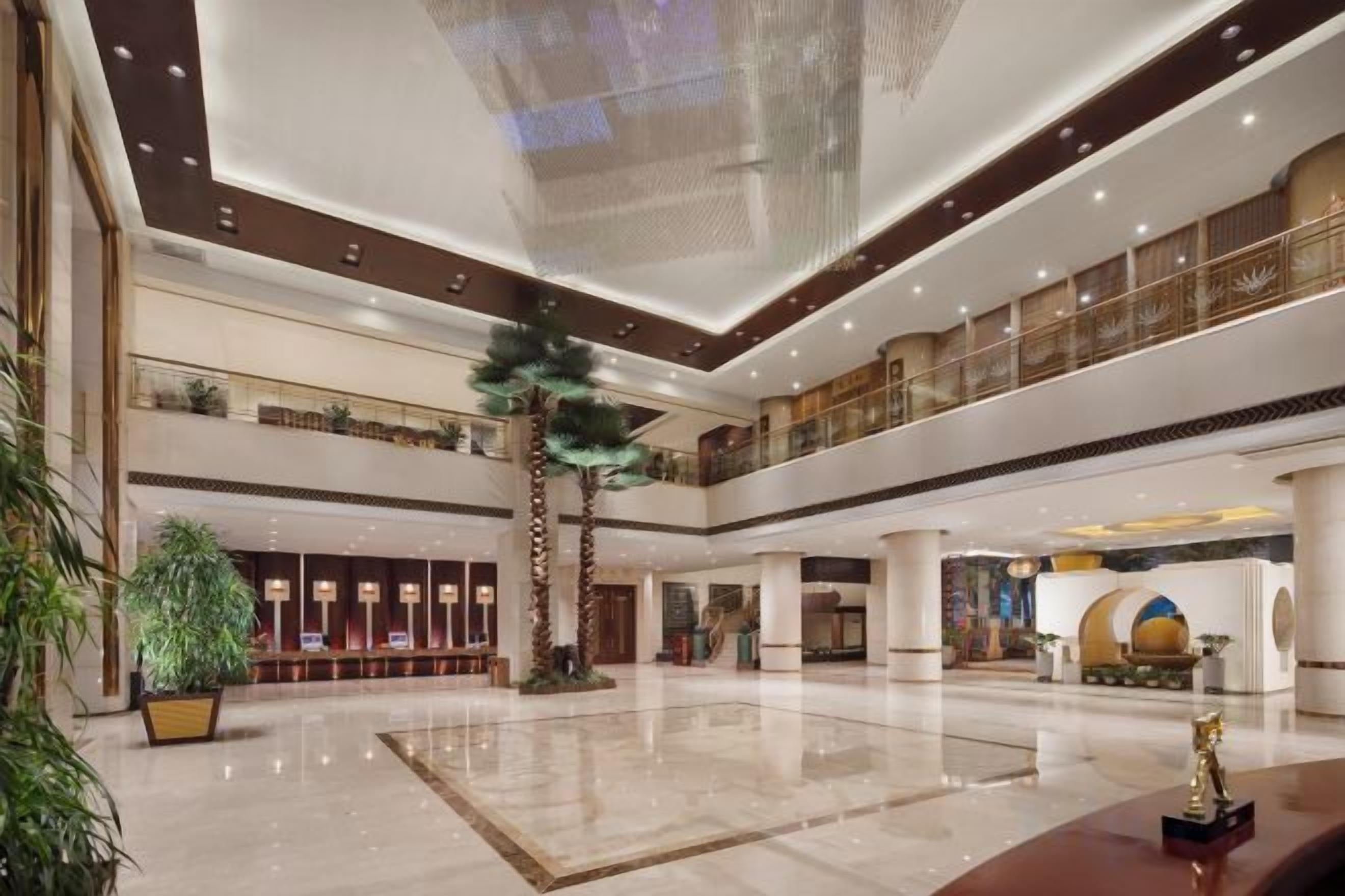 A spacious lobby with a central atrium, multiple levels, and a reception area.