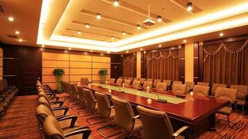 A conference room with a long table, chairs, and a modern ceiling design.