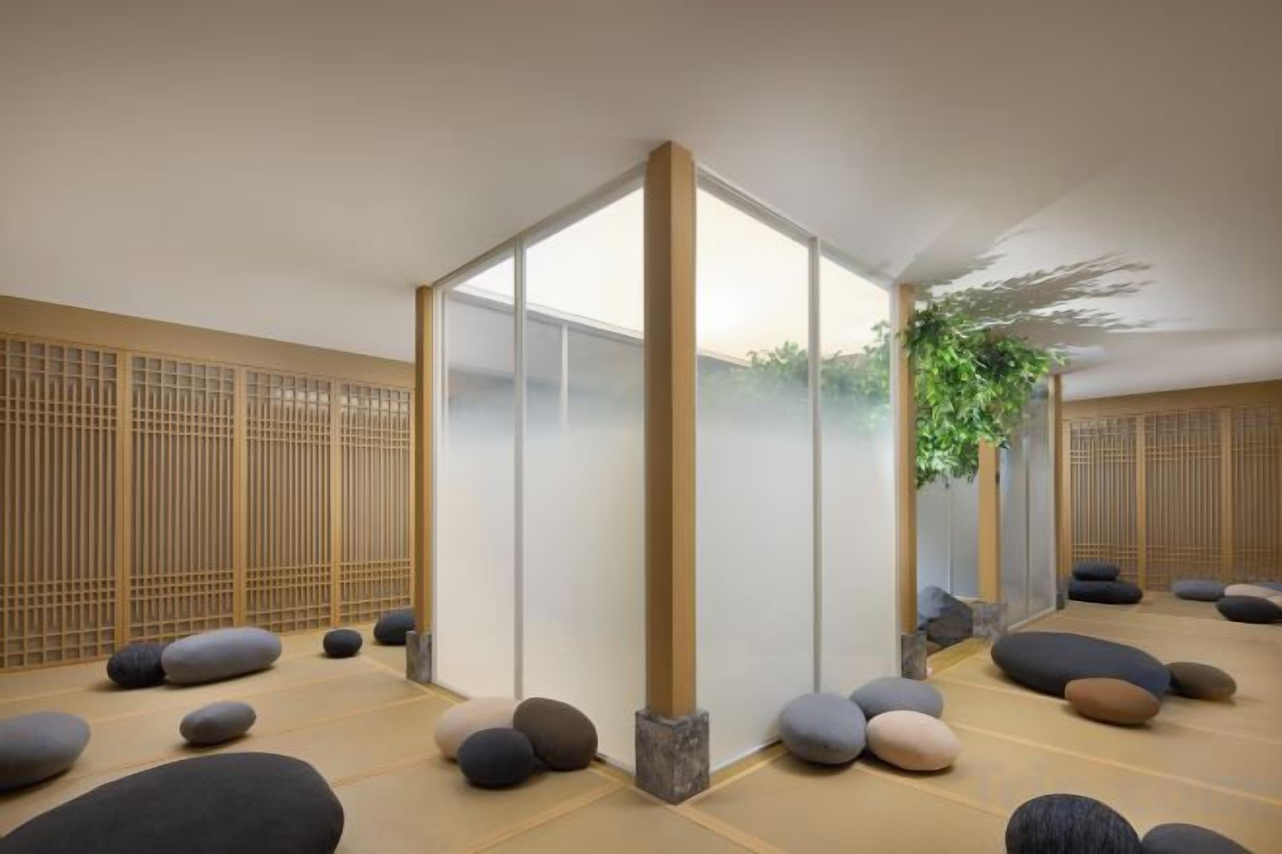 Una habitación con suelo de tatami, una puerta corredera y una planta.