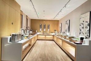 A modern hotel lobby with a central reception desk, a long counter with various amenities, and a wooden floor. - Zhuozheng International Hotel (Baoding)