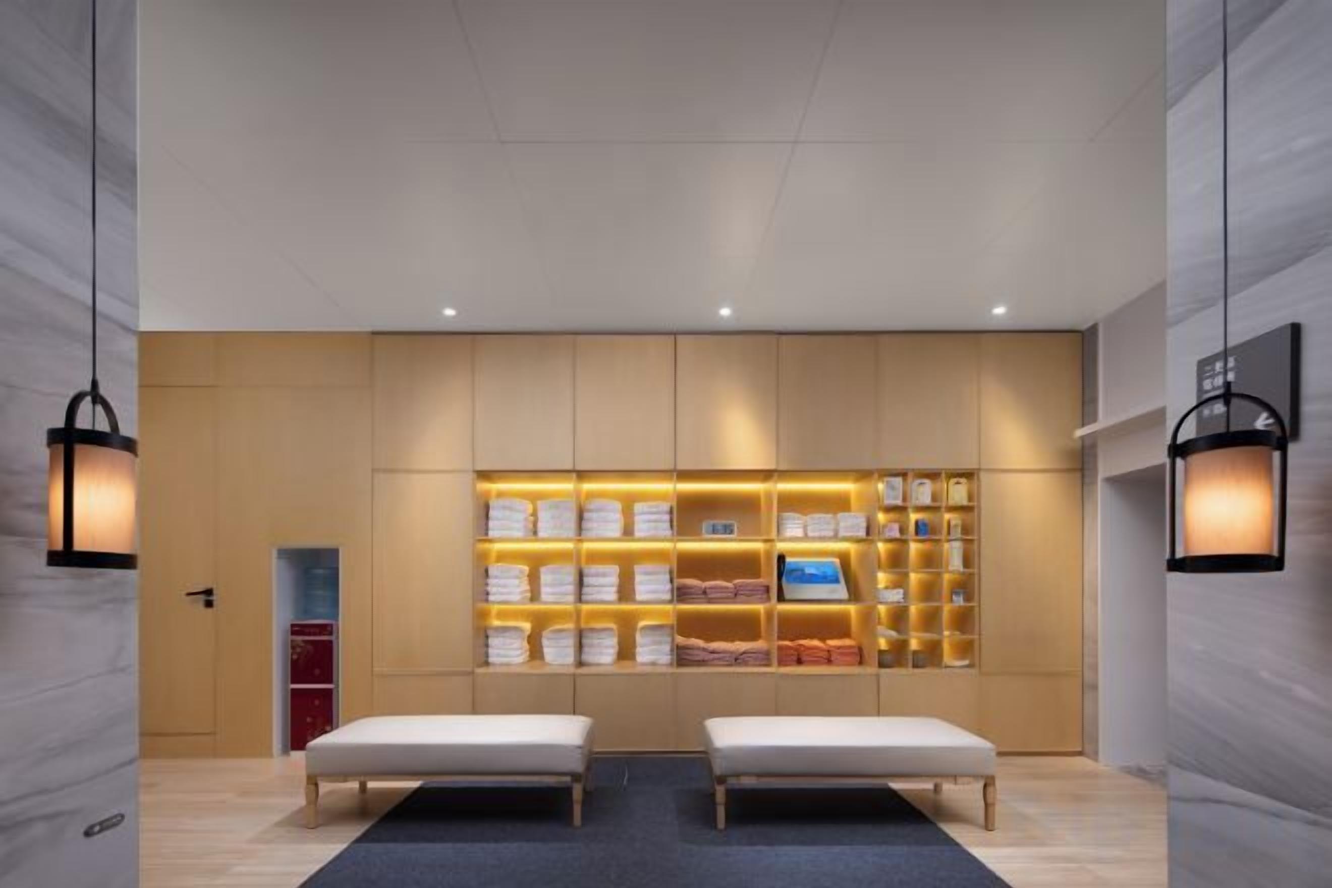 Un hall de hotel con mostrador de recepción, zona de estar y una exhibición de servicios.