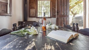 A rustic wooden table with a bottle of wine, glasses, and an open book, suggesting a cozy reading area. - El Ventorrillo Cottage, in Morón de la Frontera (Moron De La Frontera)