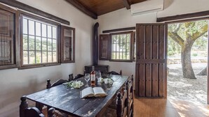 A rustic wooden dining table with a book and a bottle, flanked by wooden chairs. - El Ventorrillo Cottage, in Morón de la Frontera (Moron De La Frontera)