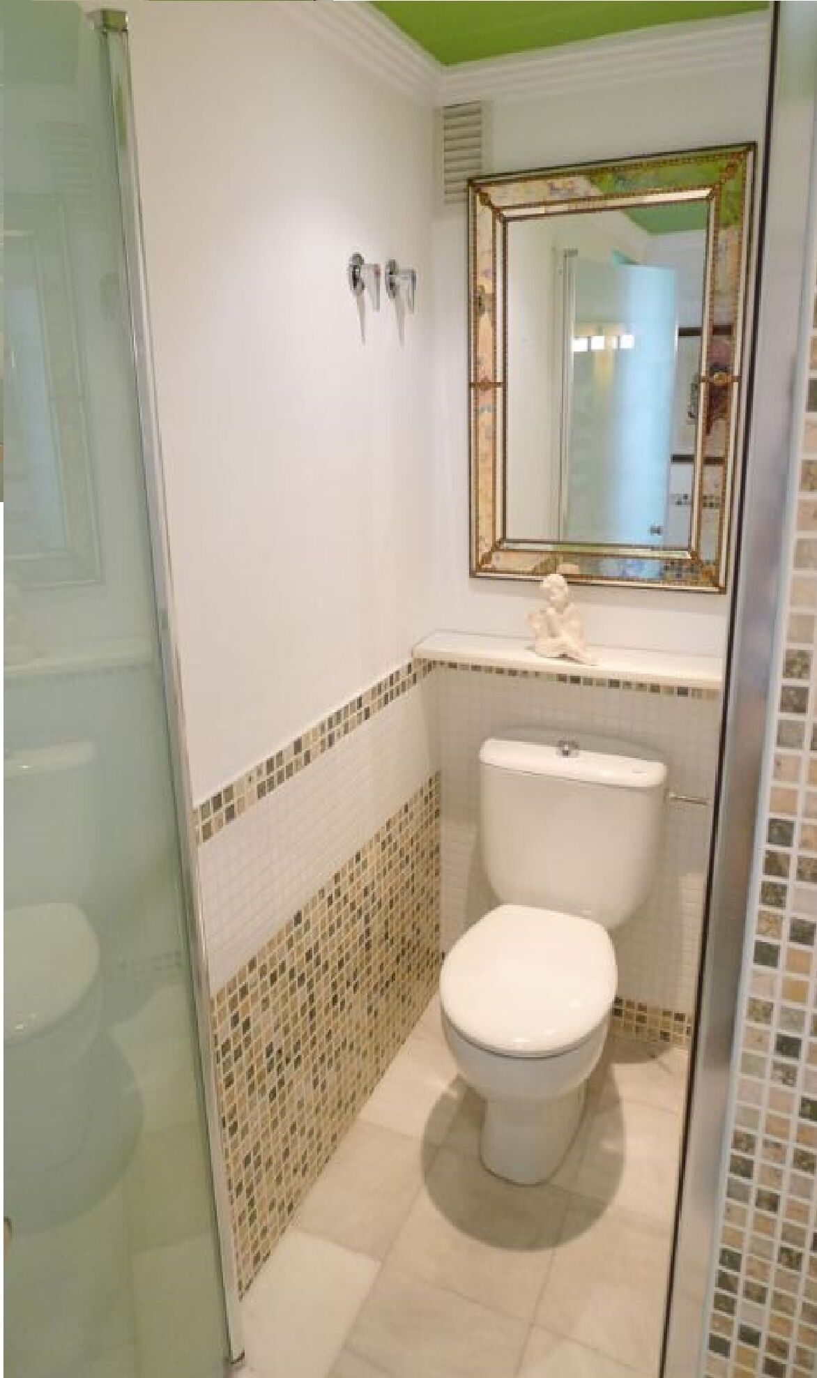 Une salle de bain avec des toilettes, un lavabo et une douche.