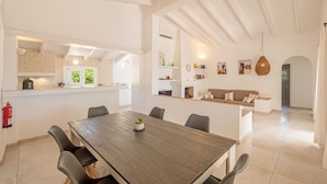 A spacious dining area with a long table, chairs, and a fire extinguisher on the wall. - Binire · Villa BiniRe ❤️ private pool ❤️ Free AC/Wifi (Binibequer)