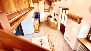 Una cocina rústica con vigas de madera, encimera azul y una estufa.