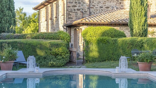 A stone building with a pool, surrounded by well-maintained hedges and potted plants. - Villa Amiata - Tuscan Farmhouse with private pool (Castel del piano)