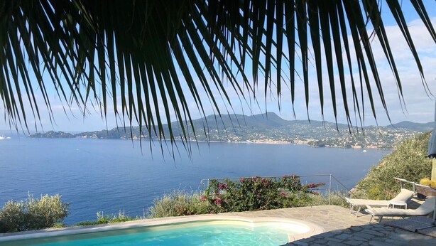 Una piscina con vista despejada al mar y la costa lejana.