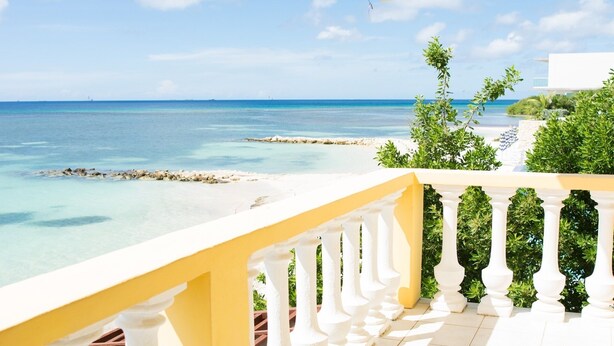 A balcony with a view of a beach and ocean.