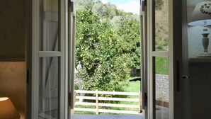 A doorway leading to a garden with a wooden fence and a stone wall. - Country house near SPILI with peaceful garden, orange trees and jacuzzi (Mixorouma)