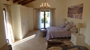 A bedroom with a large bed, a chandelier, a window with curtains, a rug, and a painting on the wall. - Villa Albero Limone Luxury 3 bedroom 4 bathooms farmhouse private pool and wif (Chiaramonte Gulfi)
