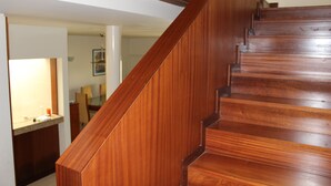 Un escalier en bois, doté d’une rampe, menant à l’étage supérieur.