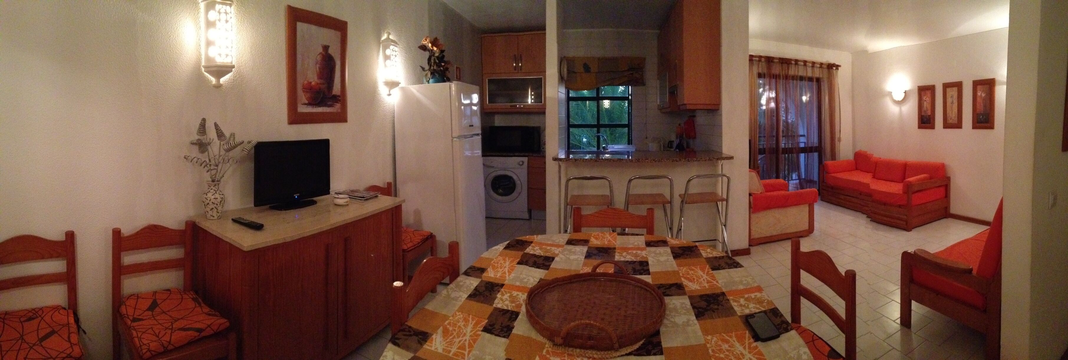 A compact living space with a dining area, kitchen, and seating.