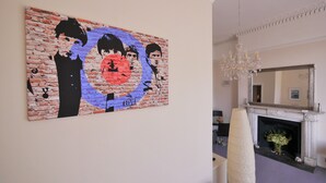 A room with a brick-patterned artwork on the wall, a fireplace, and a chandelier. - Regency Retreat  - Stylish Apartment with sea views and balcony. Great Location. (Brighton)