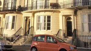 A multi-story building with a curved facade, large windows, and a small balcony with a wrought iron railing. - Regency Retreat  - Stylish Apartment with sea views and balcony. Great Location. (Brighton)