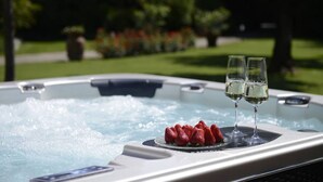 Ein Whirlpool mit zwei Sektgläsern und einer Schale Erdbeeren.