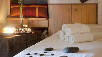 Experience a serene spa retreat with a massage table, neatly arranged towels, and soothing ambiance.