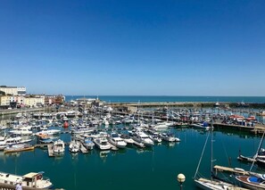 A marina with numerous boats docked, a clear sky, and buildings in the background. - Marina Retreat - Stunning 4 bed, 3 bath w/ views (Ramsgate)