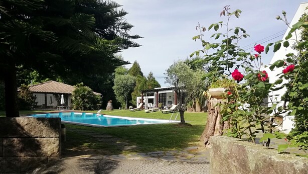 A swimming pool surrounded by a paved area, a small building, and lush greenery. - Charming chalet  with private pool and around to beaches (Espargo/Santa Maria da Feira)