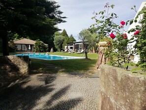 A swimming pool surrounded by a paved area, a small building, and lush greenery. - Charming chalet  with private pool and around to beaches (Espargo/Santa Maria da Feira)