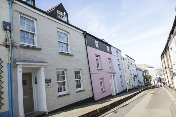 A row of traditional buildings with a sign reading "Duke House" on the white building.
