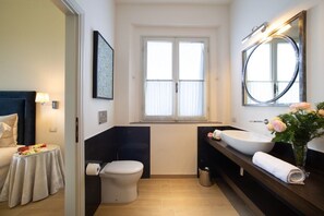 Ein modernes Badezimmer mit Toilette, einem großen Waschbecken und einem Spiegel.