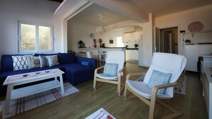 A modern living room with a blue sofa, white armchairs, and a wooden coffee table. - Brasilia 5A - Apartment in Puerto de Sóller with views to the sea and  mountains (Puerto de Sóller)