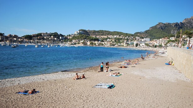 A beach with people sunbathing and swimming, a marina with boats, and buildings in the background. - Brasilia 5A - Apartment in Puerto de Sóller with views to the sea and  mountains (Puerto de Sóller)