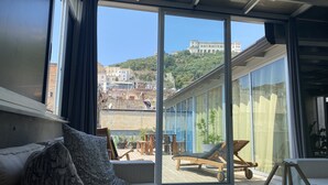 Una sala de estar moderna con un amplio ventanal corredera que da a una terraza exterior.