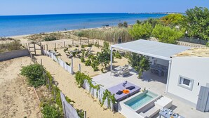 Um imóvel à beira-mar com piscina, área de estar externa e vista para o mar.