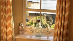 A window with a view of a body of water and greenery. - Seaweed Cottage in Fowey overlooking the beach with a garden and a parking space (Fowey)