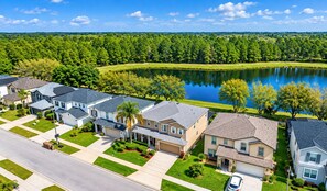 A residential area with houses, a road, and a lake.