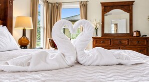 A hotel room with a bed, a lamp, a dresser, and a mirror.