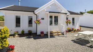A white building with a sloped roof, a front porch with steps, and a gravel driveway. - Scandinavian Cabin near Bude with Log Burner (Kilkhampton)