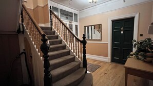 Una escalera de madera con barandillas y peldaños alfombrados que llevan a un piso superior.