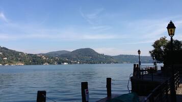 A lakeside view with a dock, a lamp post, and a sign indicating no entry.