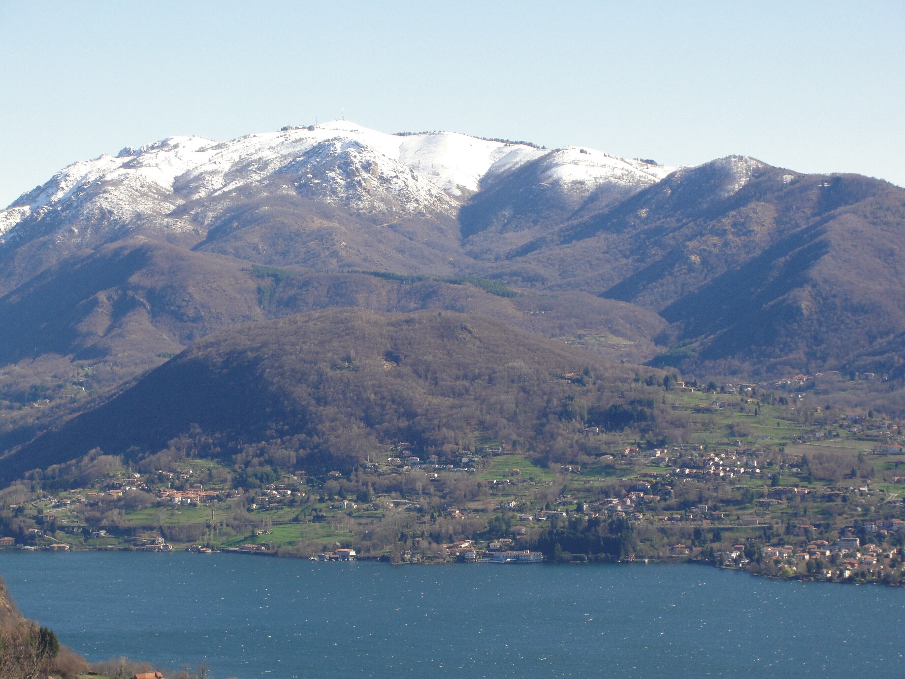 Un paisaje montañoso con un pueblo a orillas de un lago.