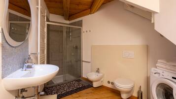 Une salle de bain équipée d’un lavabo, d’un bidet, de toilettes et d’un lave-linge.