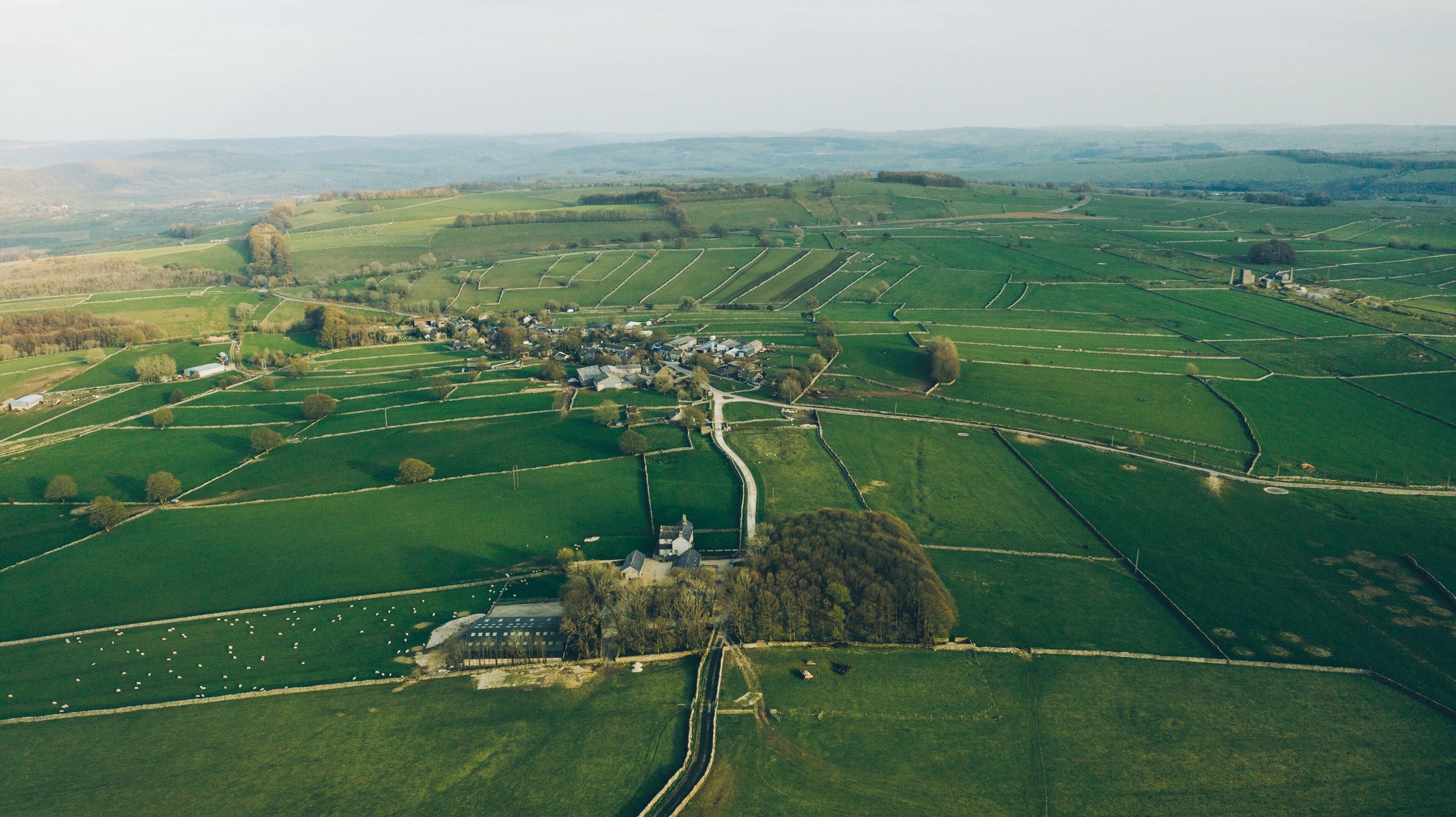 Vista aérea de un paisaje rural con campos, un pequeño pueblo e iglesia.