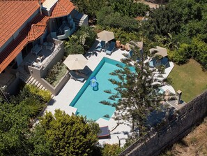 An aerial view of a resort with a swimming pool, lounge chairs, and a covered seating area. - Alonia Villa, Refined Living with 50m² Private Pool (Rethymno)