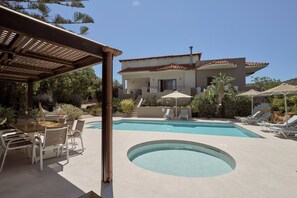 A pool area with lounge chairs and a dining table. - Alonia Villa, Refined Living with 50m² Private Pool (Rethymno)
