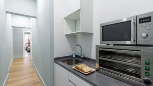 Una cucina moderna con forno a microonde, forno e lavello integrati.