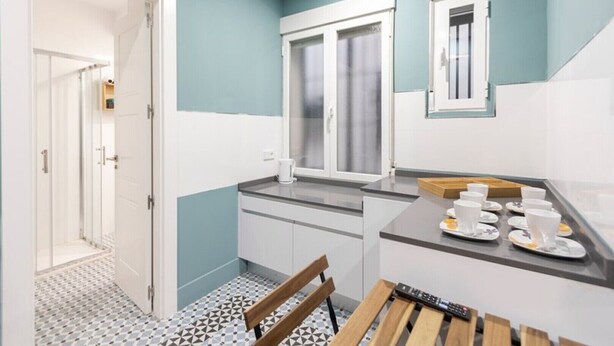 Una cucina compatta con una finestra, un angolo caffè e un'area pranzo con tavolo e sedie.